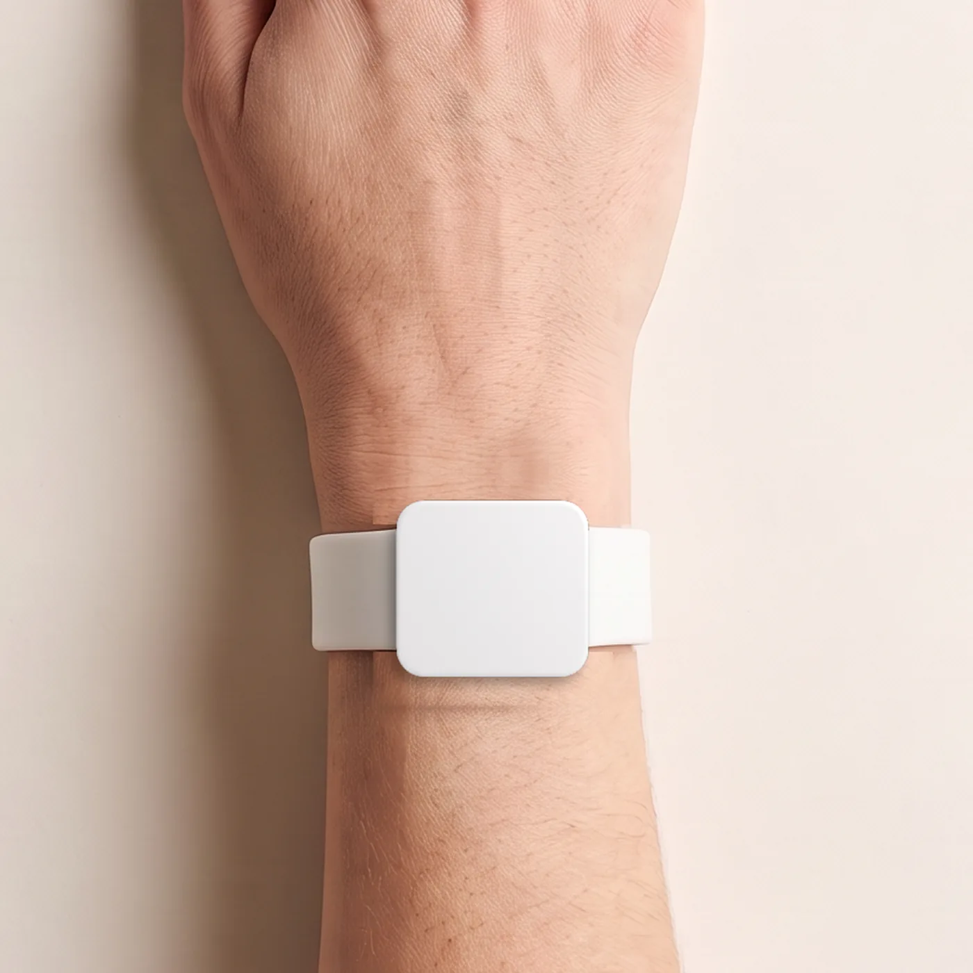 Boo on a wrist, seen from above: a slim white rounded-square module on a soft white strap.